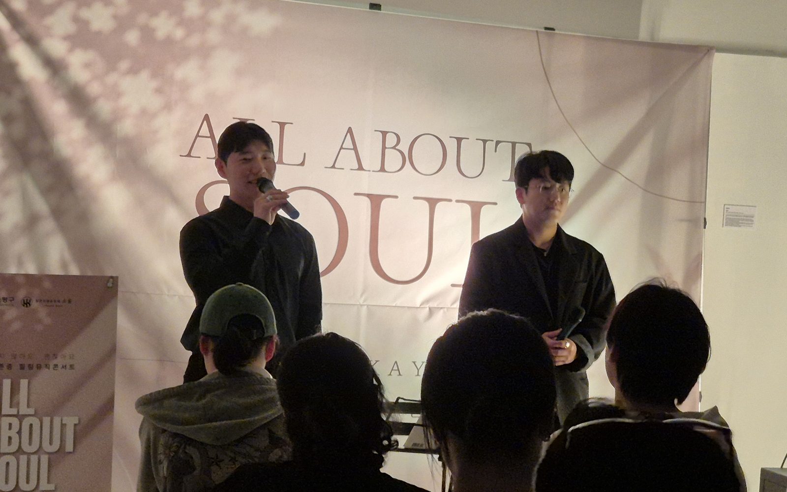 「ALL ABOUT SOUL」 현수막 앞 무대에 선 배우 두 명과 객석의 뒷모습